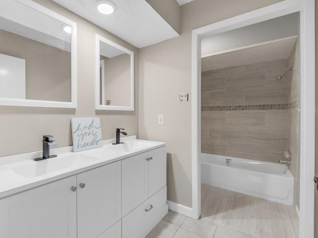 bathroom with vanity, tile patterned floors, and tiled shower / bath