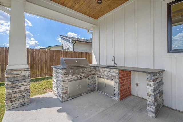 view of patio featuring grilling area, sink, and an outdoor kitchen