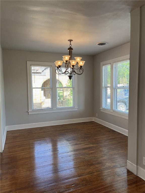 unfurnished dining area with plenty of natural light, visible vents, baseboards, and dark wood-style floors