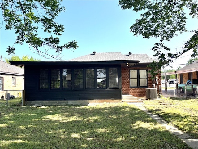 back of property featuring fence, a yard, and central air condition unit