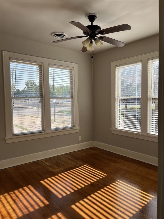 spare room with ceiling fan, baseboards, dark wood-style flooring, and visible vents