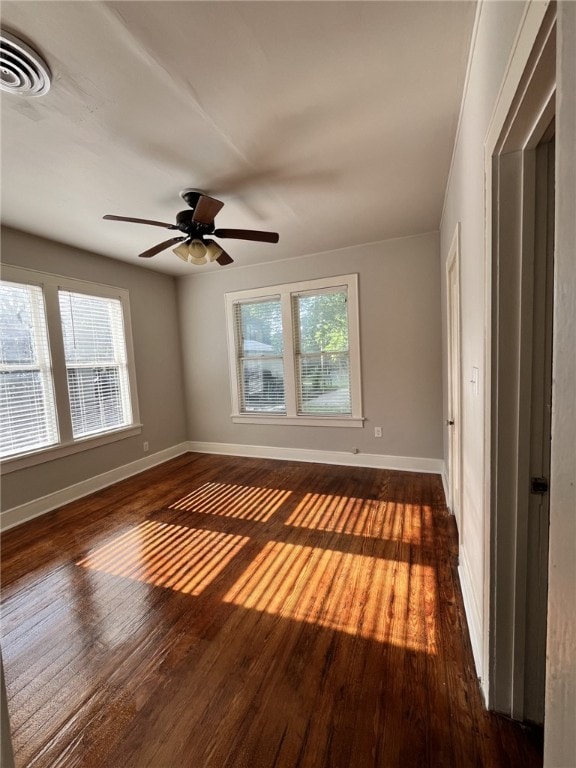 spare room featuring plenty of natural light, visible vents, and dark wood-style flooring
