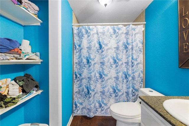 bathroom featuring hardwood / wood-style flooring, vanity, walk in shower, toilet, and a textured ceiling