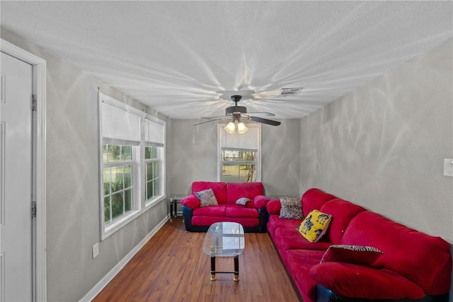 living room with ceiling fan, hardwood / wood-style floors, and a textured ceiling