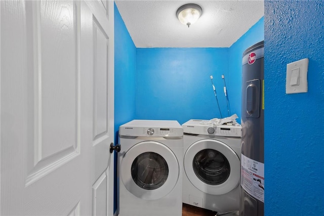 laundry room featuring water heater, separate washer and dryer, and a textured ceiling