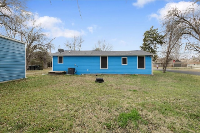 back of house featuring a lawn and central air condition unit