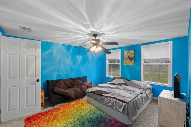 bedroom featuring ceiling fan, carpet flooring, and a textured ceiling