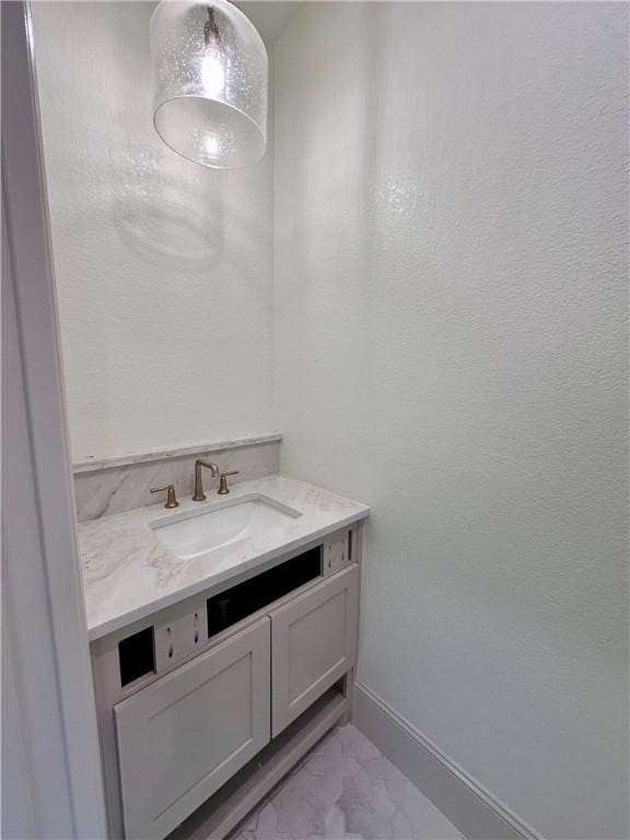 bathroom featuring marble finish floor, vanity, and baseboards