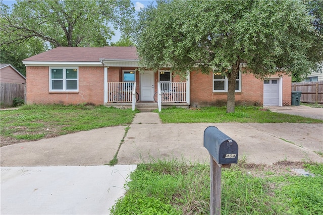 view of front facade featuring brick siding, driveway, fence, and covered porch