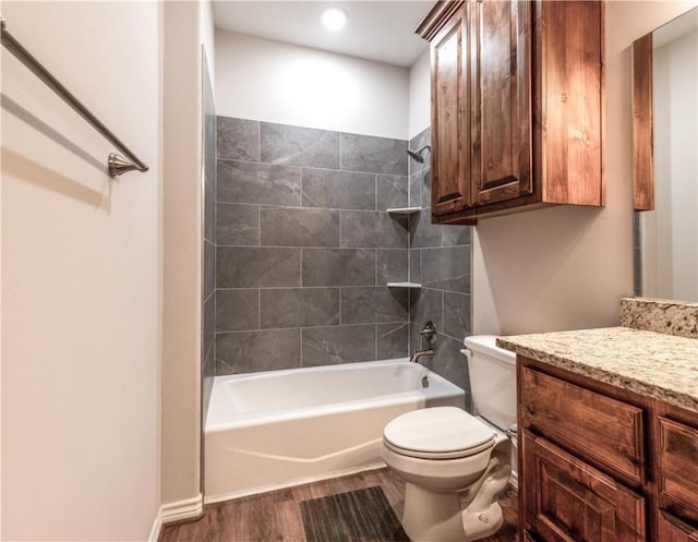 full bathroom featuring toilet, vanity, wood-type flooring, and tiled shower / bath