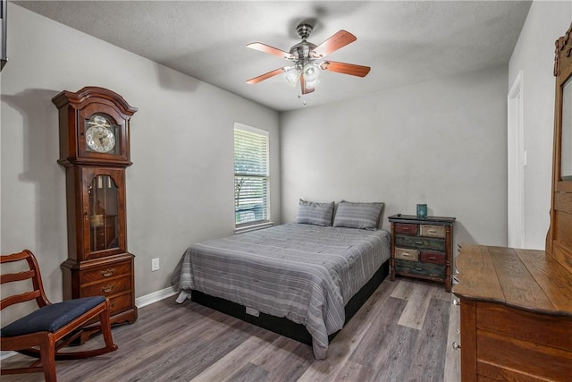 bedroom featuring hardwood / wood-style floors, a textured ceiling, and ceiling fan