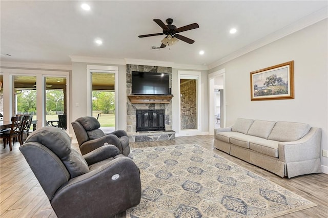 living room featuring a fireplace, light hardwood / wood-style floors, ceiling fan, and ornamental molding