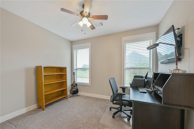 carpeted home office featuring ceiling fan