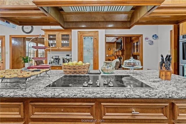 kitchen with light stone countertops and black electric cooktop