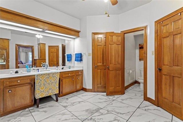 bathroom with ceiling fan, toilet, and vanity