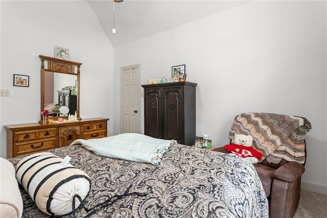 carpeted bedroom with high vaulted ceiling