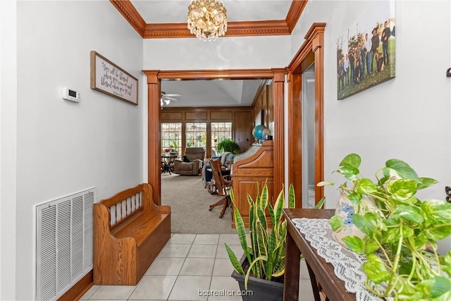 hall featuring a chandelier, light colored carpet, and crown molding