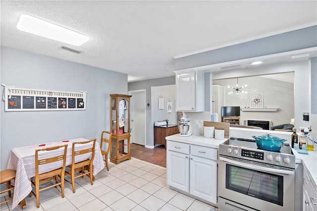 kitchen with a notable chandelier, visible vents, white cabinetry, electric stove, and light countertops