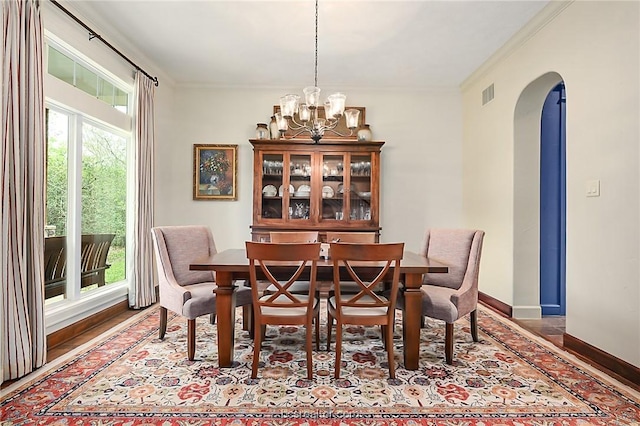 1650 Bird Pond Rd, College Station, TX 77845 - dining space featuring arched walkways, wood finished floors, a chandelier, baseboards, and ornamental molding