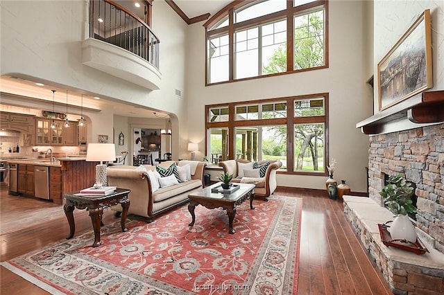 1650 Bird Pond Rd, College Station, TX 77845 - living room featuring hardwood / wood-style floors, a fireplace, crown molding, a towering ceiling, and baseboards