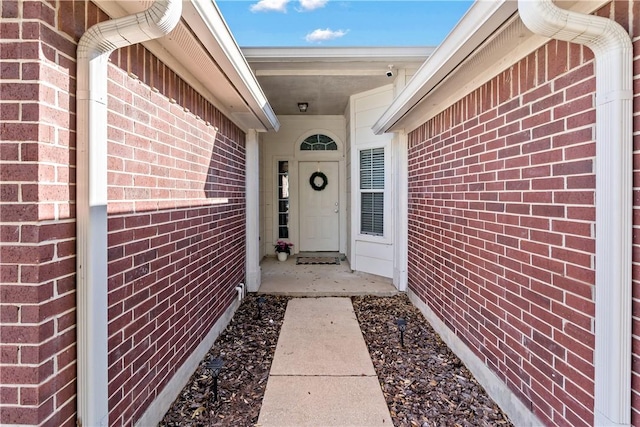 view of exterior entry with brick siding