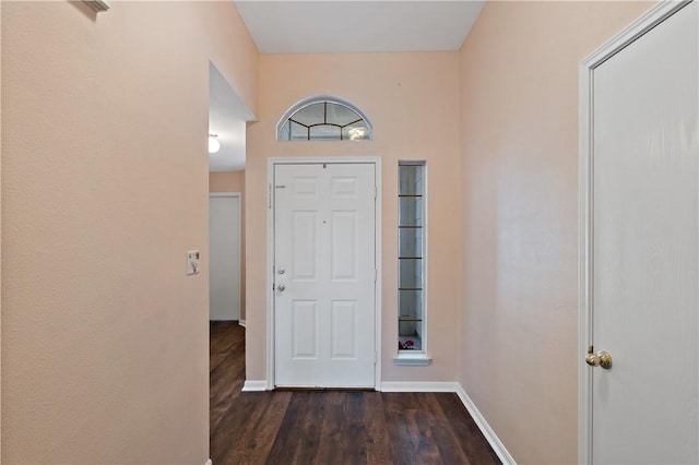 foyer featuring baseboards and dark wood finished floors