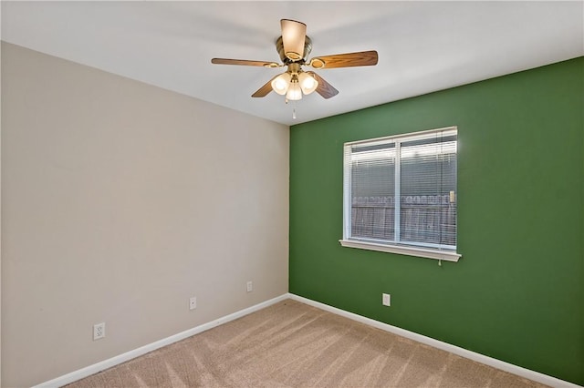 unfurnished room with baseboards, carpet floors, and a ceiling fan