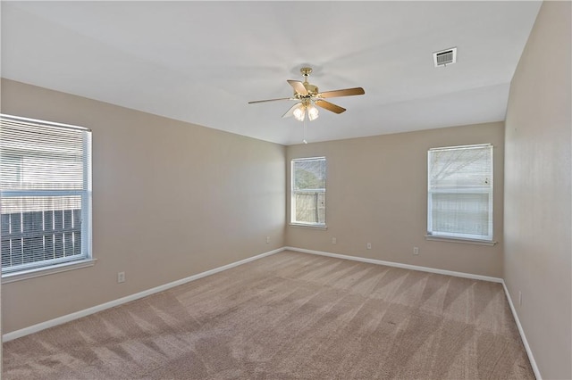 unfurnished room featuring light carpet, visible vents, plenty of natural light, and baseboards