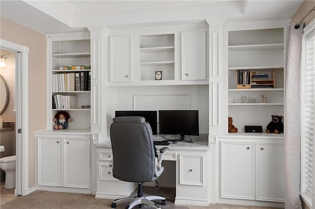 home office with a raised ceiling, light colored carpet, and crown molding