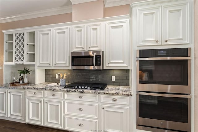 kitchen with decorative backsplash, crown molding, white cabinets, and appliances with stainless steel finishes