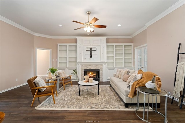 living room with ceiling fan, a fireplace, crown molding, and dark hardwood / wood-style floors