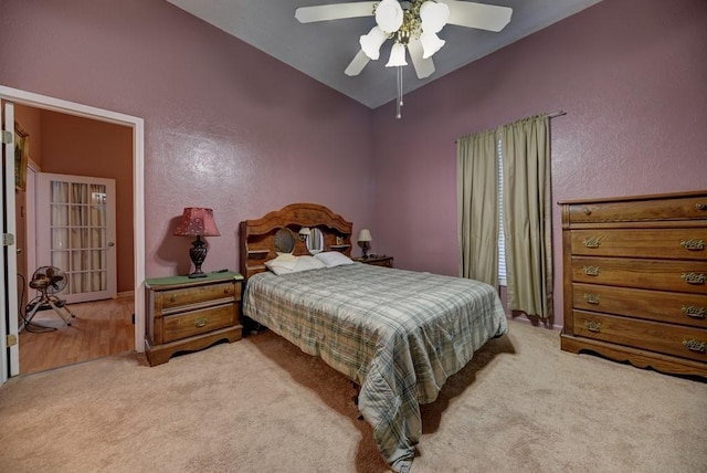 bedroom featuring ceiling fan, light colored carpet, and lofted ceiling