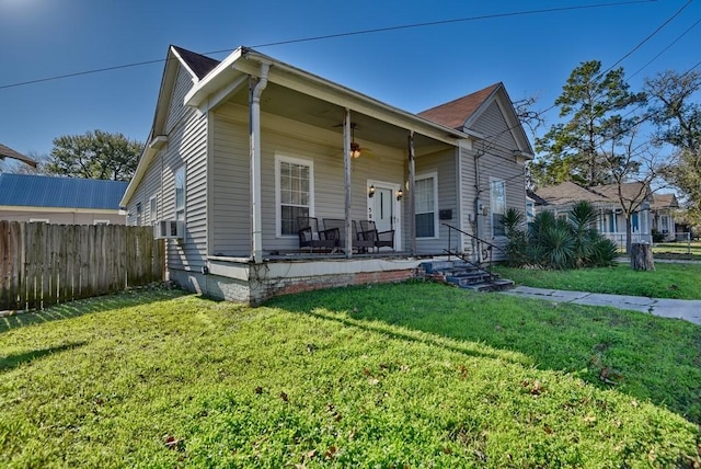 bungalow-style home featuring a front lawn, a porch, cooling unit, and ceiling fan