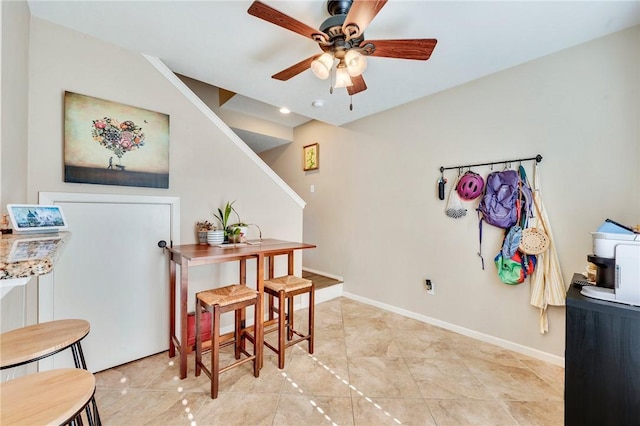 dining space featuring a ceiling fan and baseboards