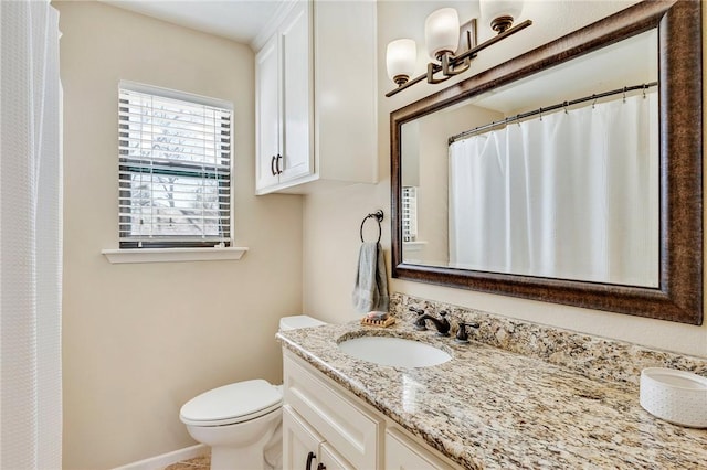 full bathroom with toilet, vanity, and baseboards