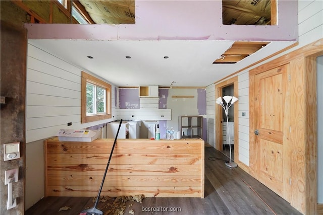 kitchen featuring dark hardwood / wood-style flooring and wooden walls