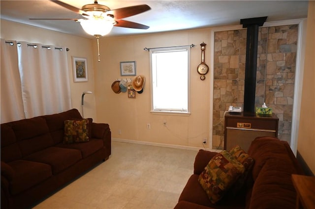 living room featuring ceiling fan and a wood stove