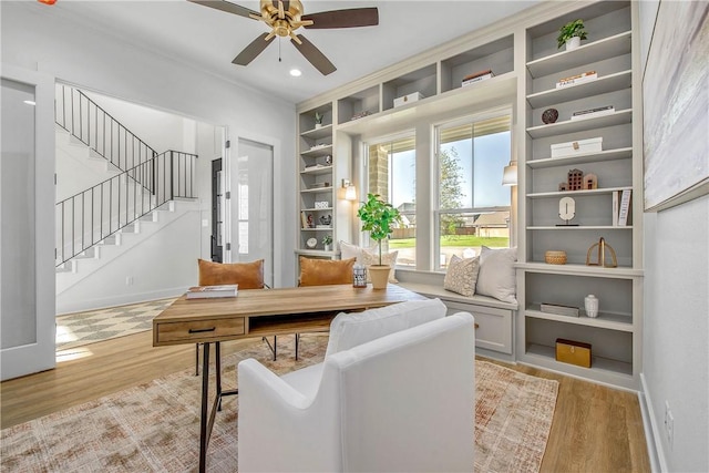 office area featuring light wood-type flooring, built in shelves, ceiling fan, baseboards, and recessed lighting