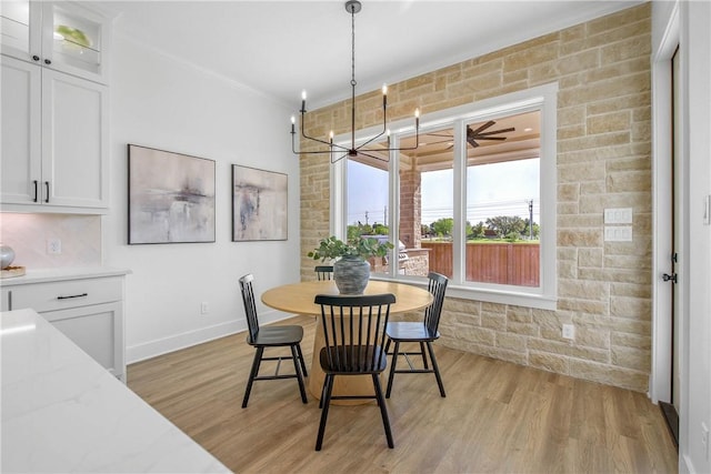 dining room with a notable chandelier, baseboards, light wood-style floors, and ornamental molding