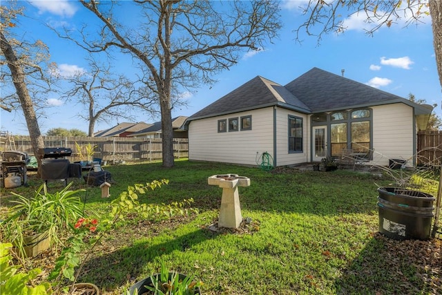 rear view of property featuring a yard