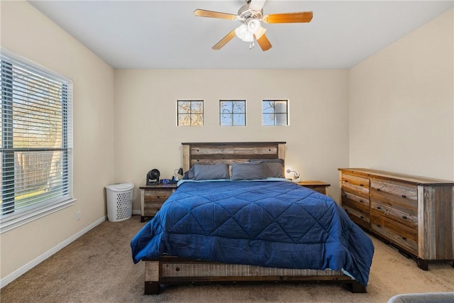 bedroom with ceiling fan, light carpet, and multiple windows