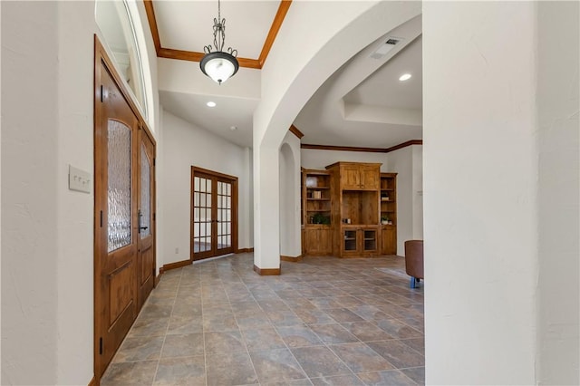 foyer entrance featuring visible vents, ornamental molding, french doors, arched walkways, and baseboards