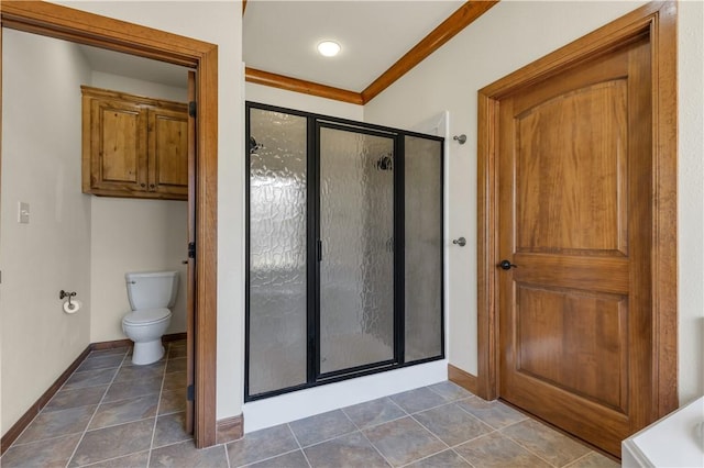 bathroom featuring tile patterned flooring, toilet, baseboards, and a stall shower