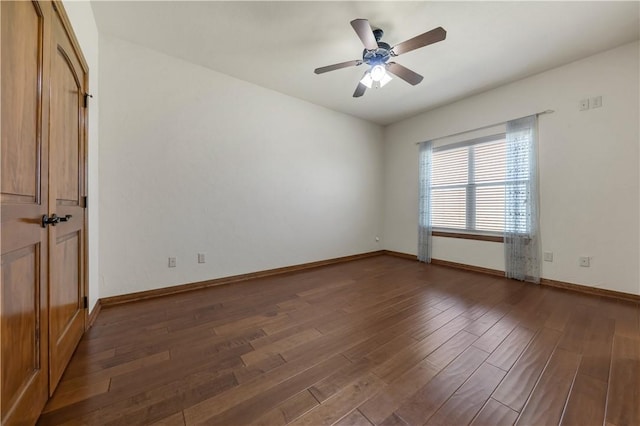 spare room with ceiling fan, baseboards, and wood finished floors