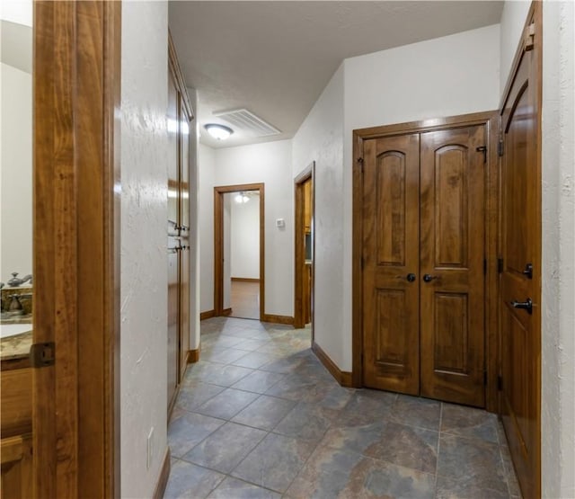 hall with baseboards and visible vents