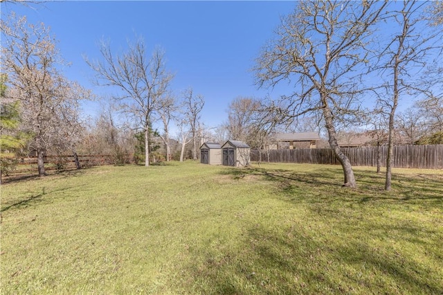 view of yard with a storage shed, an outdoor structure, and fence