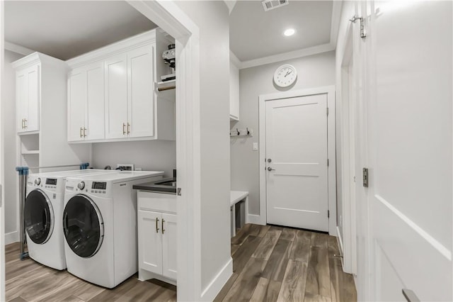 4813 Coopers Hawk Dr, College Station, TX 77845 - laundry room with cabinet space, washing machine and clothes dryer, and wood finished floors