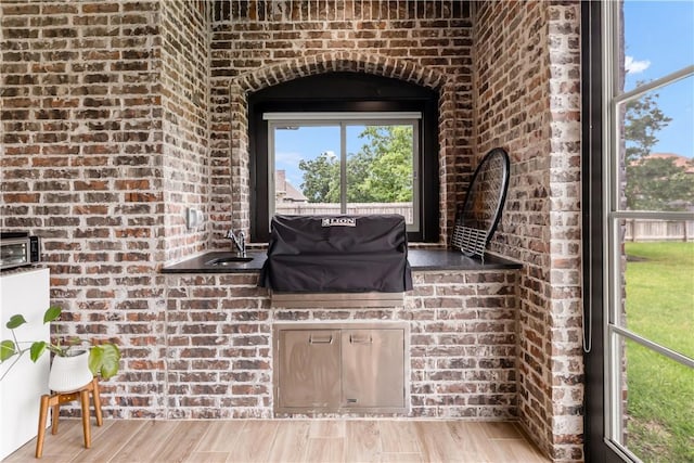 4813 Coopers Hawk Dr, College Station, TX 77845 - detailed view of brick wall, wood finished floors, and a sink