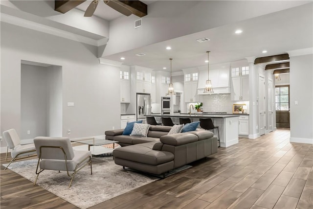 4813 Coopers Hawk Dr, College Station, TX 77845 - living room featuring baseboards, light wood-style floors, a ceiling fan, recessed lighting, and a high ceiling