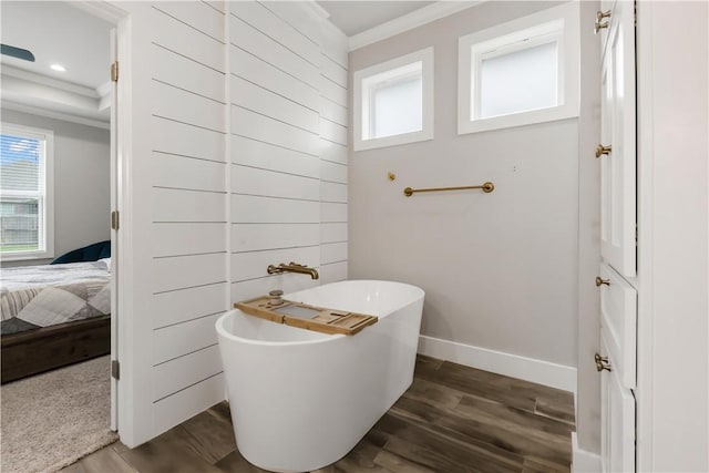 4813 Coopers Hawk Dr, College Station, TX 77845 - bathroom with healthy amount of natural light, ornamental molding, a soaking tub, wood finished floors, and baseboards